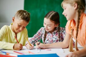 Three students working in a classroom.